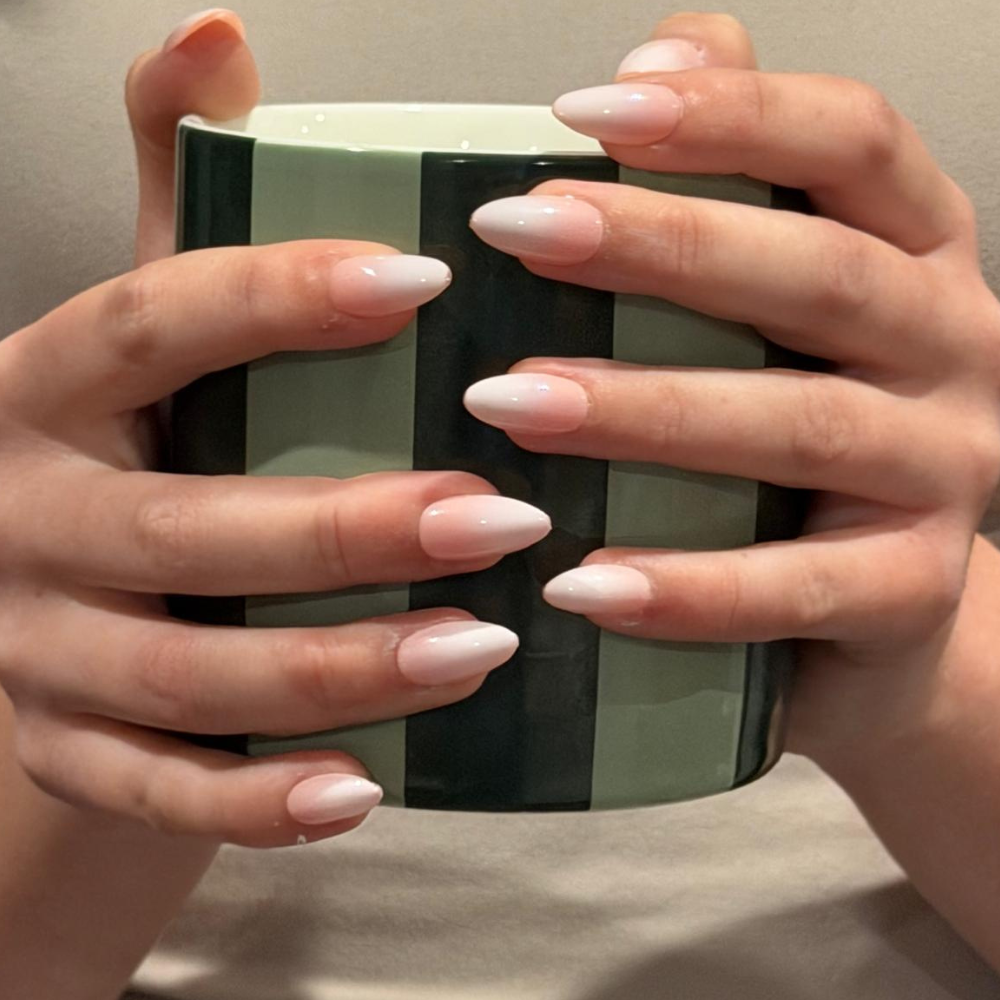 A hand holding a mug wearing Cloud Kiss Press On Nails from Sugar Tips