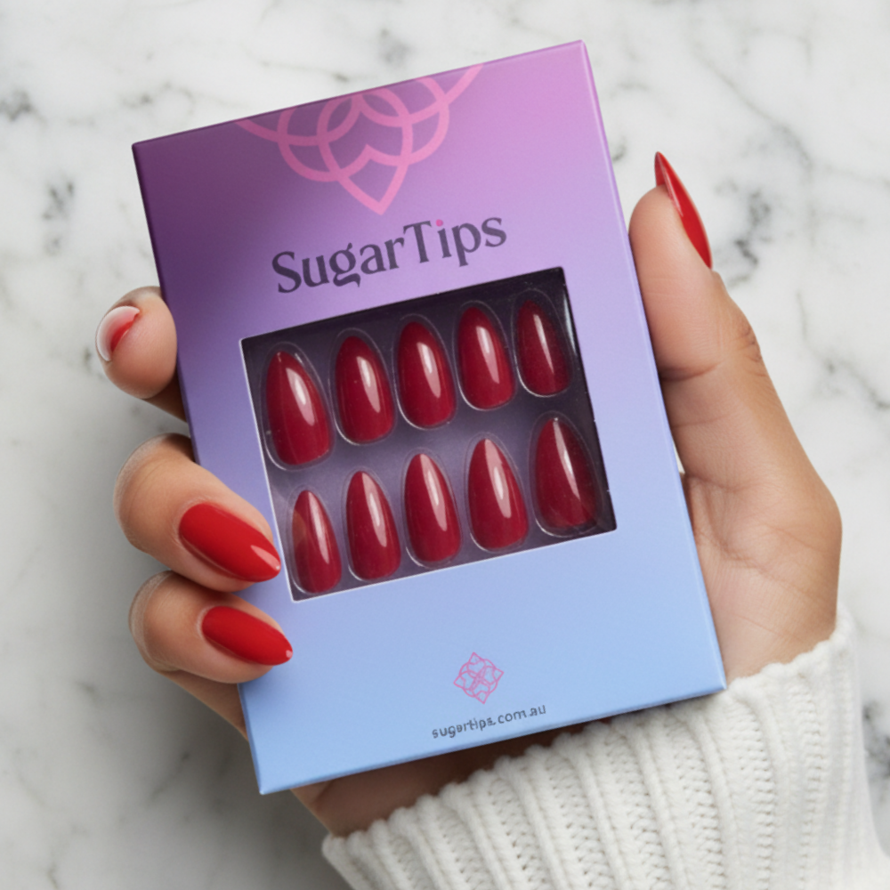 Hand Holding a Box of Sugar Tips Scarlet Fever Long Red Almond press-on nails
