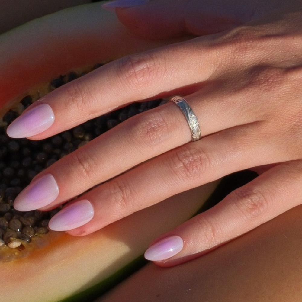 Cotton Candy lilac pink ombré press-on nails in medium almond by Sugar Tips, close-up with an engraved silver ring