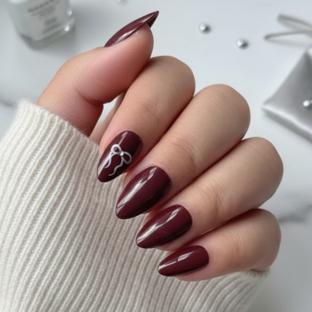 Sugar Tips Forbidden Bloom Glossy Dark Red Almond press-on nails with bow detail front view.