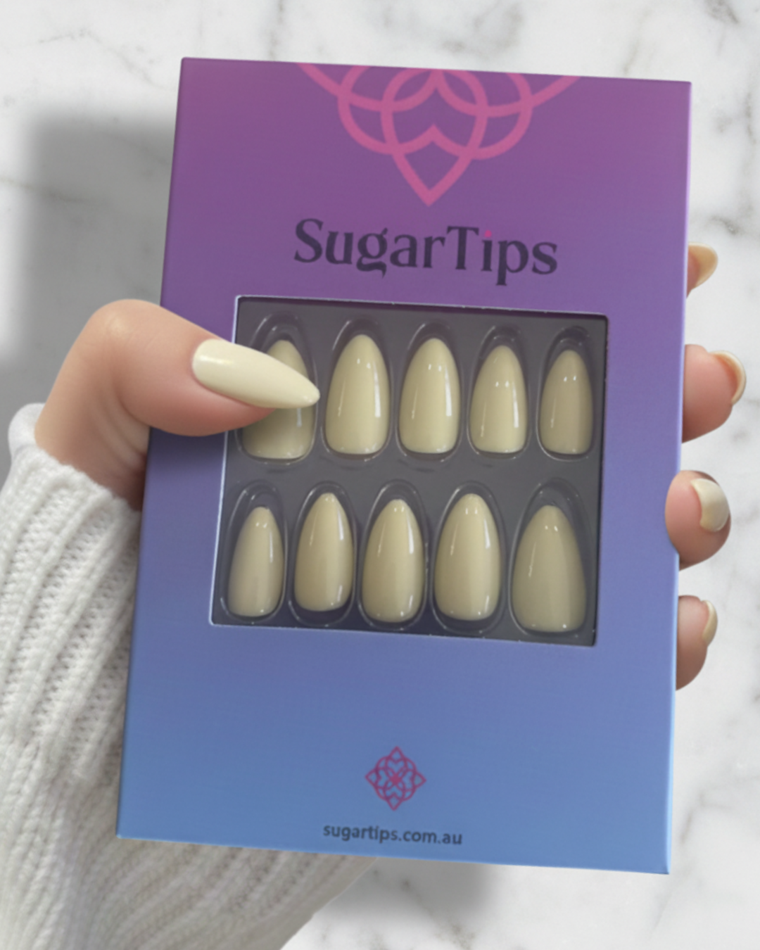 Hand Holding a box of Sugar Tips Butter Glow Yellow Butter Almond Press-On Nails